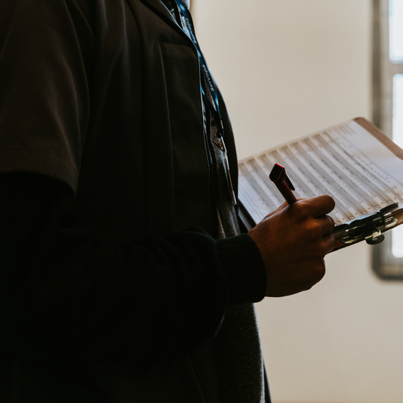 Man holding a pen and a clipboard with a paper checklist