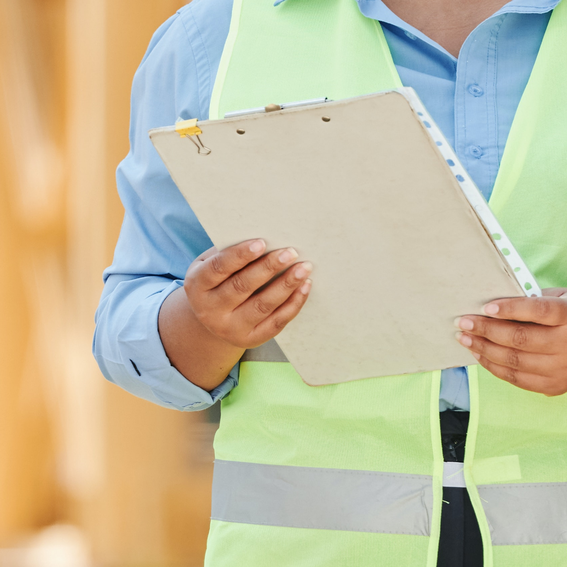 A woman in a green hi-vis jacket holding a clipboard