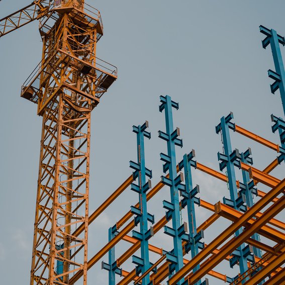 crane in front of blue and orange metal infrastructure