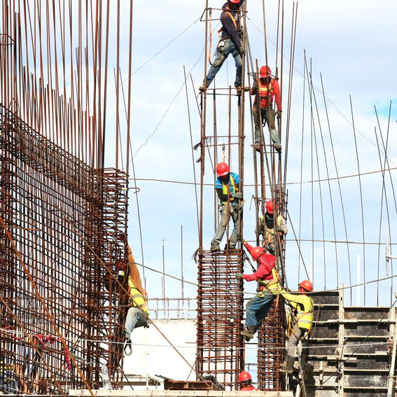 Workers on site, erecting steel poles